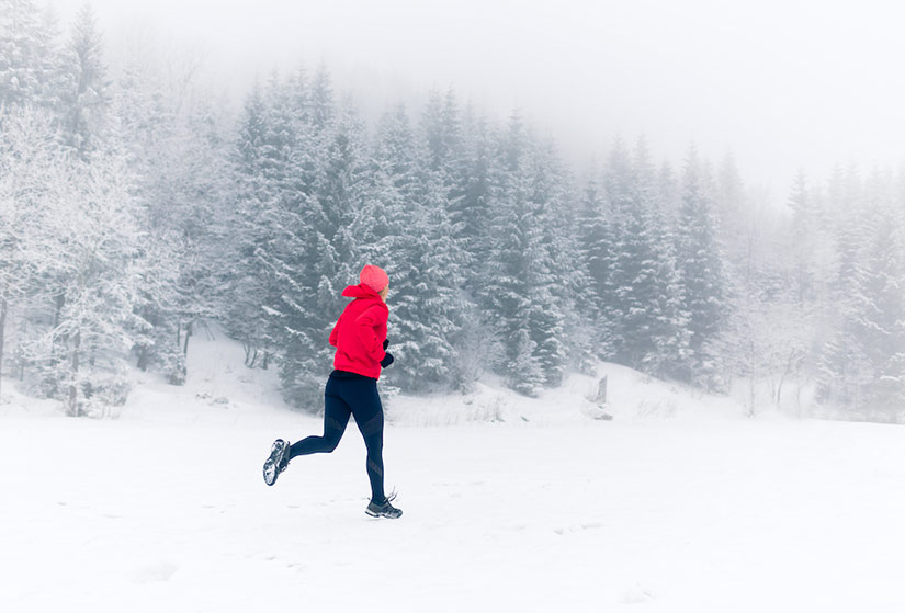 Une Femme Fait Du Jogging Dans Une Forêt D'hiver Dans Des Vêtements De  Sport Et Des écouteurs Chauds